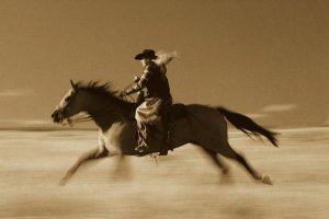 Konrad Wothe - Cowgirl on Horse running through field, Oregon - Sepia