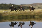 Konrad Wothe - Cowboys riding Horses with dogs running beside pond, Oregon