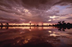 Gerry Ellis - Sunset and storm clouds over waterhole, Linyanti Swamp, Botswana