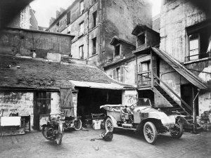 Eugène Atget - Automobile and two motorcycles in front of garage, Cour, Rue de Valence, Paris, France, early 20th Century