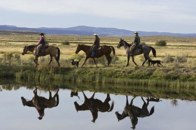 Konrad Wothe - Cowboys and a cowgirl riding Horses beside pond, Oregon