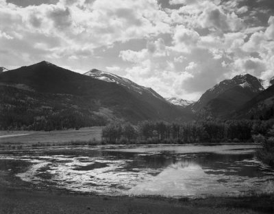 Ansel Adams - Lake and trees in foreground, mountains and clouds in background, in Rocky Mountain National Park, Colorado, ca. 1941-1942